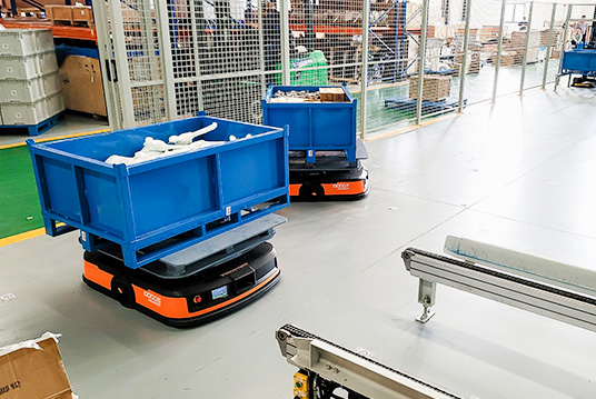 Automated guided vehicle AGV transporting bins in warehouse automation system