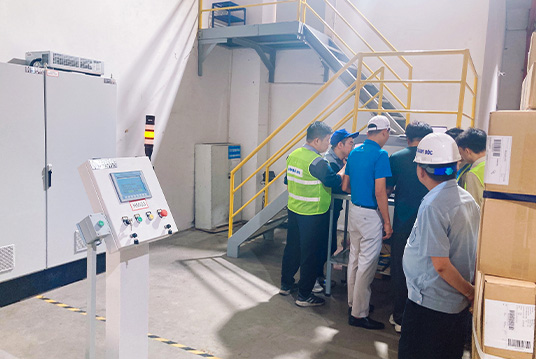 Engineers providing on-site operational training for customer staff during automated warehouse project deployment