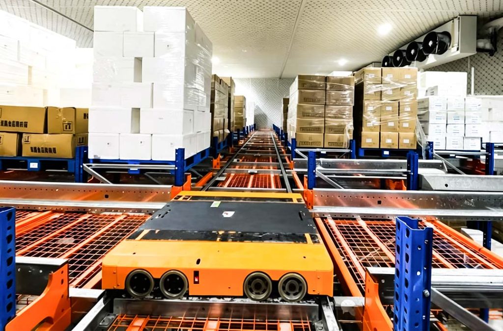 Four way pallet shuttle carrying a pallet inside an automated warehouse racking system