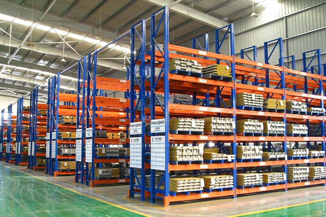 Mobile pallet racking system with movable rack bases for high-density warehouse storage.
