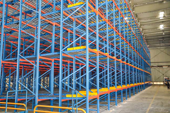 Pallet flow racking system using gravity rollers for FIFO pallet storage.