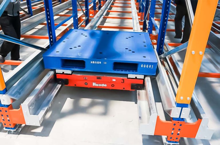 Single-directional pallet shuttle transporting a pallet inside a high-density radio shuttle racking system