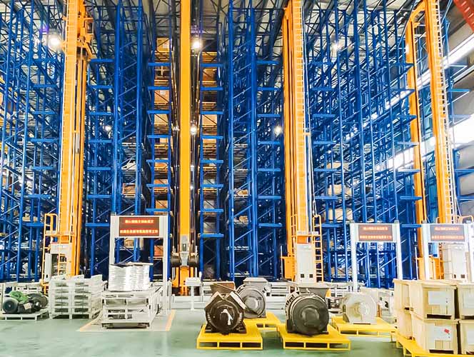 Stacker cranes operating in the aisles of a high-bay AS/RS warehouse for steel products
