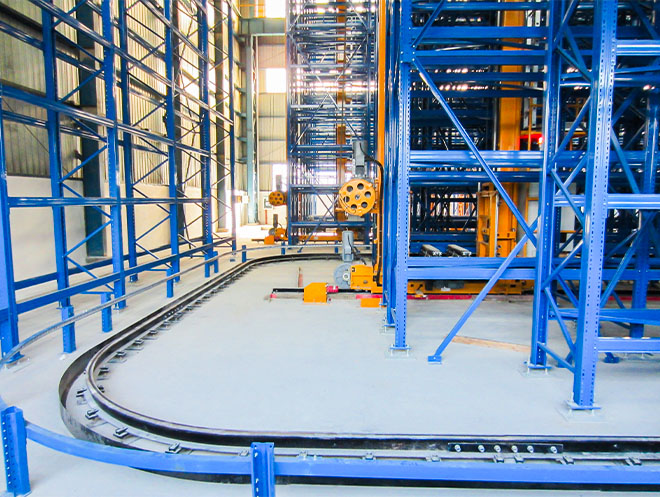 Curved-rail automated stacker and ASRS crane running on curved rails between high-bay racking