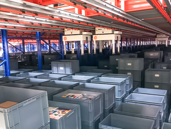 Spider tote picking robots moving through storage racks to retrieve totes from different storage levels.