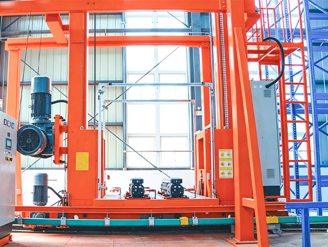 Transfer-rail automated stacker and ASRS crane moving between warehouse aisles on a transfer vehicle